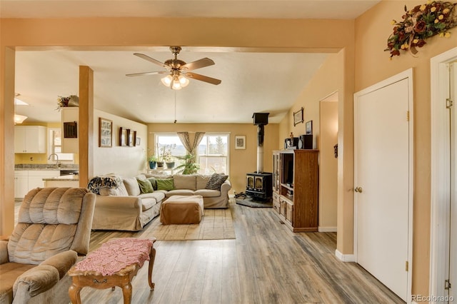 15980 County Road 306, Buena Vista, CO 81211 - living room featuring baseboards, a ceiling fan, a wood stove, and light wood-type flooring