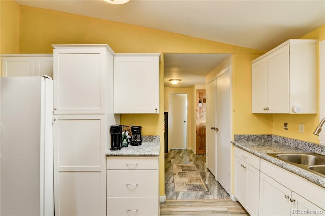 15980 County Road 306, Buena Vista, CO 81211 - kitchen with freestanding refrigerator, a sink, lofted ceiling, and white cabinetry