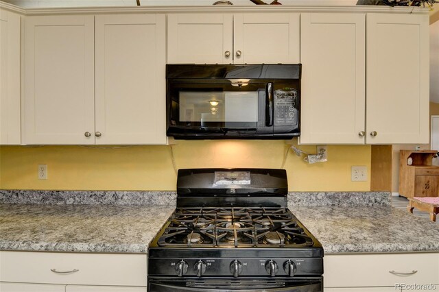 15980 County Road 306, Buena Vista, CO 81211 - kitchen with light stone counters, black appliances, and white cabinetry