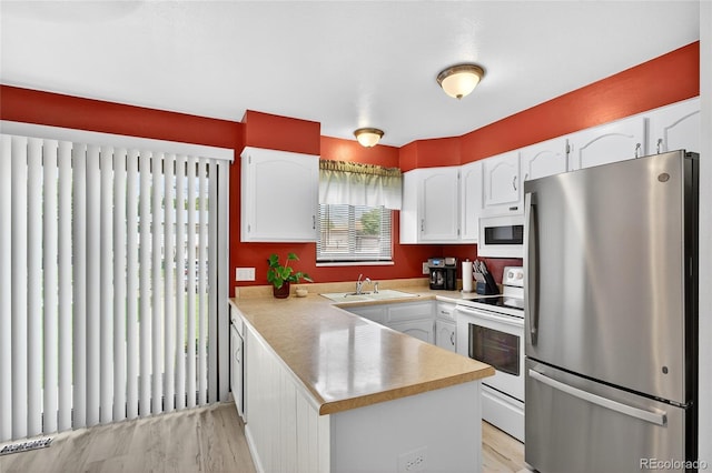3947 W Ohio Ave, Denver, CO 80219 - kitchen with white appliances, white cabinets, a peninsula, and light countertops