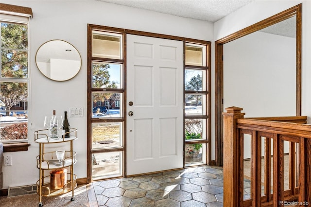 foyer entrance featuring a textured ceiling