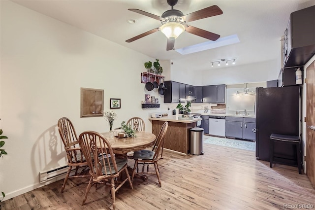 dining room featuring sink, rail lighting, light wood-type flooring, and ceiling fan