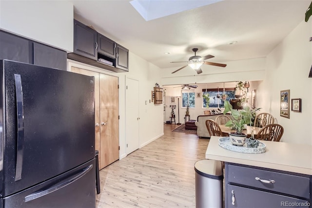 kitchen featuring light hardwood / wood-style floors, black refrigerator, and ceiling fan