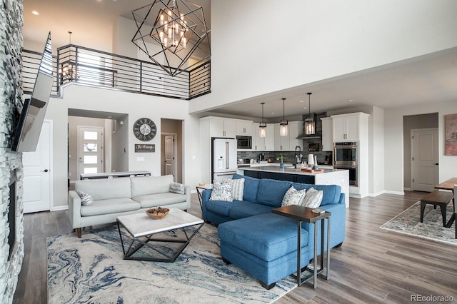 695 Simmental Loop, Castle Rock, CO 80104 - living area featuring a towering ceiling, dark wood-style floors, baseboards, a chandelier, and recessed lighting