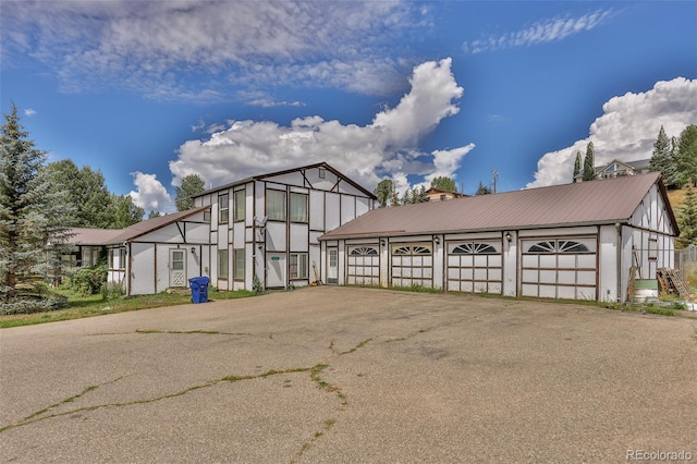 view of front of house with metal roof and driveway