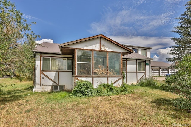 view of side of property with metal roof and a lawn