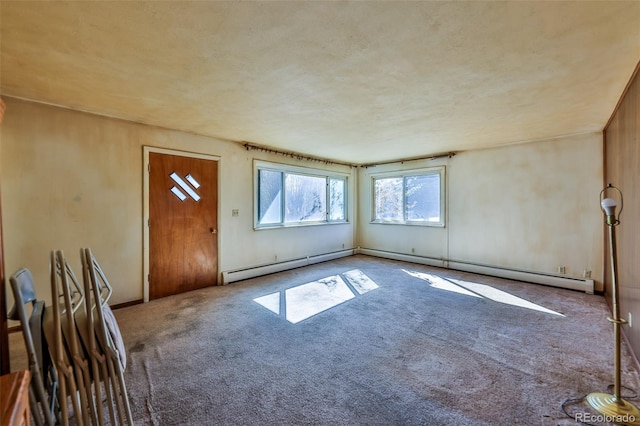 carpeted spare room with a baseboard heating unit