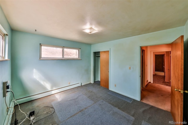 unfurnished bedroom featuring baseboard heating, dark carpet, a closet, and baseboards