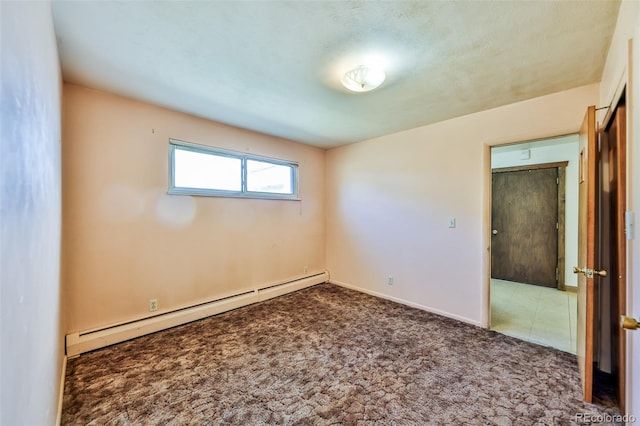 empty room with carpet floors, a textured ceiling, and a baseboard heating unit