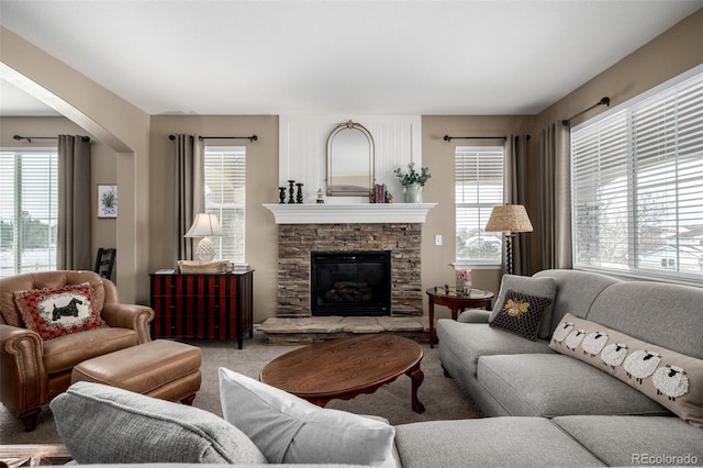 carpeted living area with a healthy amount of sunlight and a fireplace