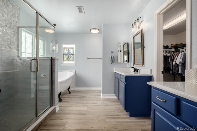 bathroom featuring a soaking tub, visible vents, vanity, a shower stall, and wood finished floors