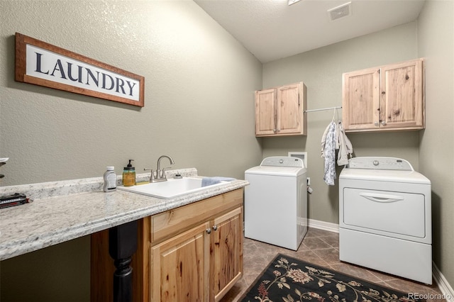 washroom with cabinet space, visible vents, washing machine and clothes dryer, tile patterned flooring, and a sink