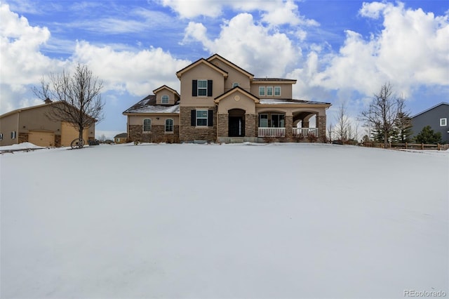 view of front of home with a porch, stone siding, a garage, and stucco siding