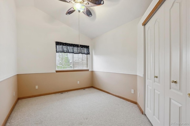 unfurnished bedroom featuring carpet flooring, vaulted ceiling, and a closet