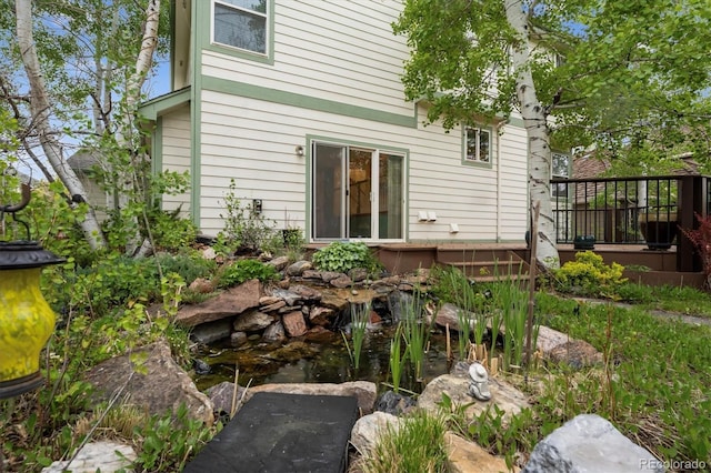 248 Summit Trl, Broomfield, CO 80020 - rear view of house with a garden pond and a wooden deck