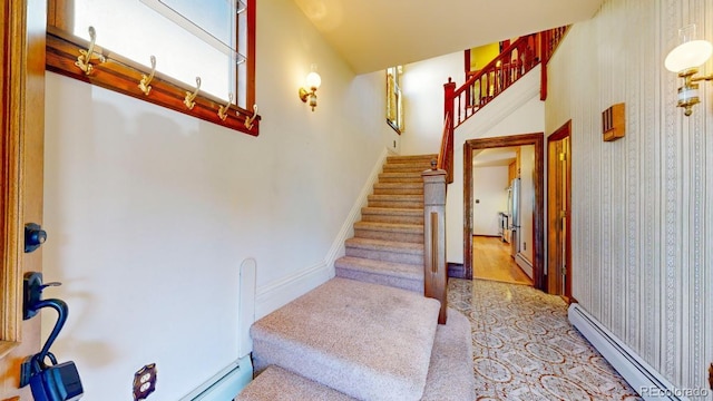 staircase featuring a baseboard radiator and baseboards