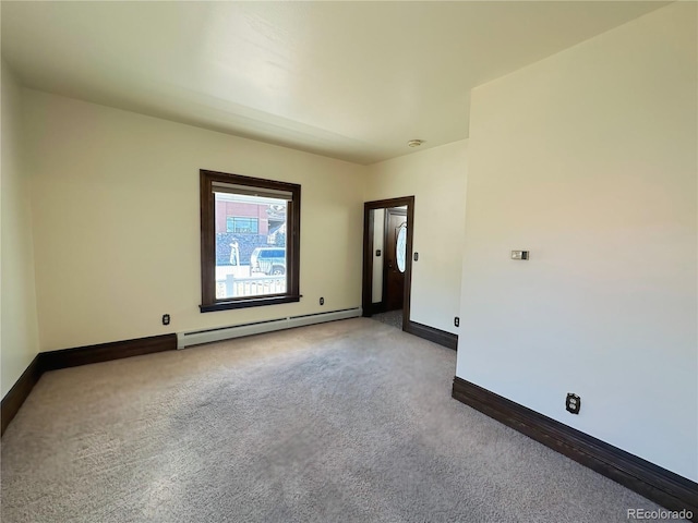 spare room with carpet, baseboards, and a baseboard radiator