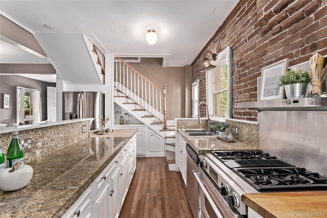368 S Humboldt St, Denver, CO 80209 - kitchen with a sink, stainless steel appliances, plenty of natural light, dark wood-style flooring, and brick wall
