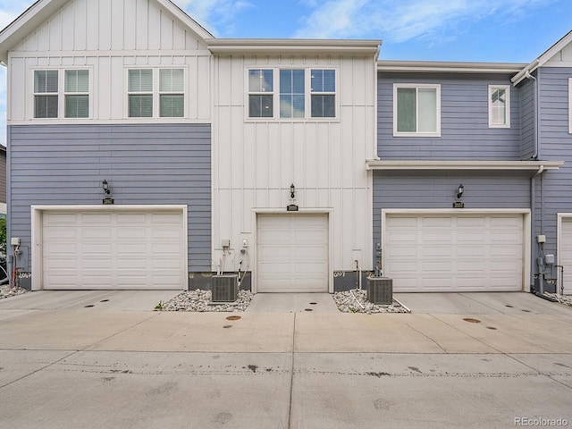 2059 S Vance Way, Denver, CO 80227 - view of front of property with board and batten siding, driveway, a garage, and cooling unit