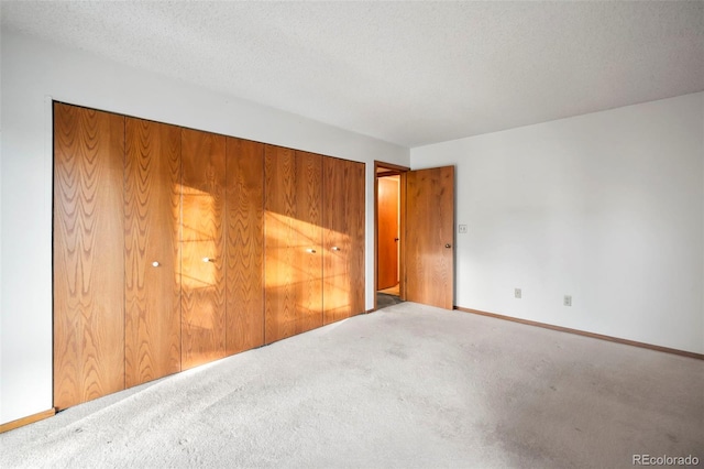 carpeted empty room featuring baseboards and a textured ceiling