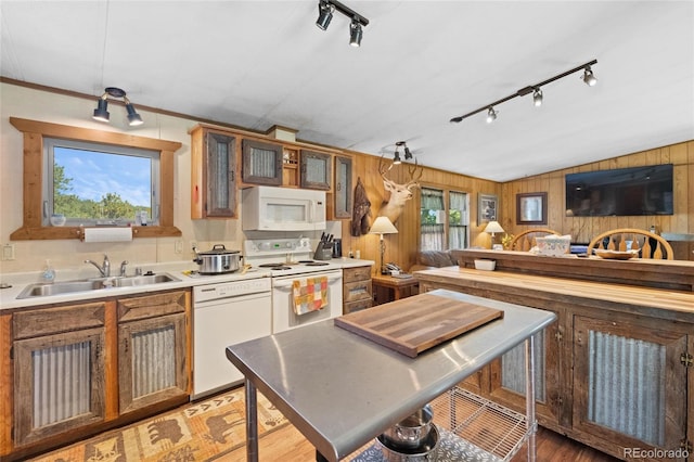 kitchen with wooden walls, sink, white appliances, and ornamental molding