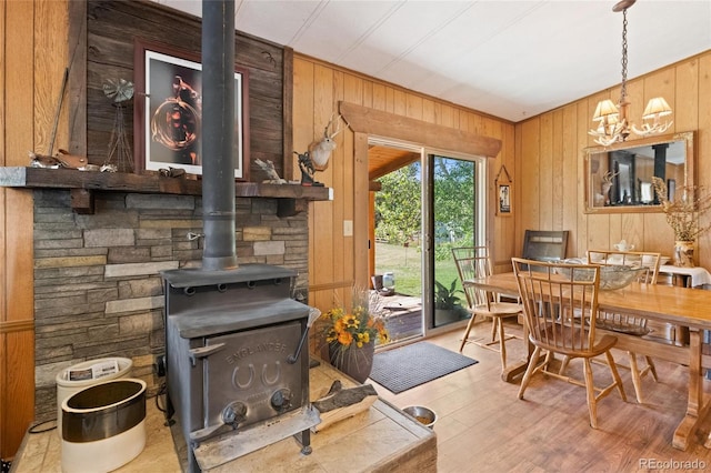10000 State Highway 96, Westcliffe, CO 81252 - dining area with wood walls, a wood stove, a chandelier, and wood finished floors