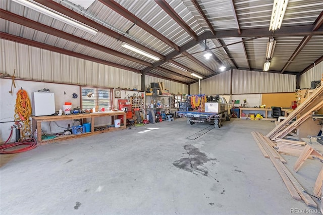 garage with a workshop area and white fridge