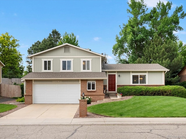 13762 W 67th Pl, Arvada, CO 80004 - split level home with concrete driveway, a garage, and brick siding