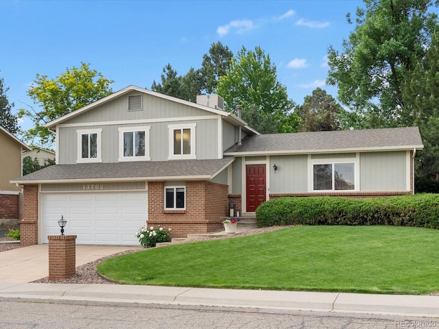 13762 W 67th Pl, Arvada, CO 80004 - tri-level home with concrete driveway, a front yard, an attached garage, and brick siding