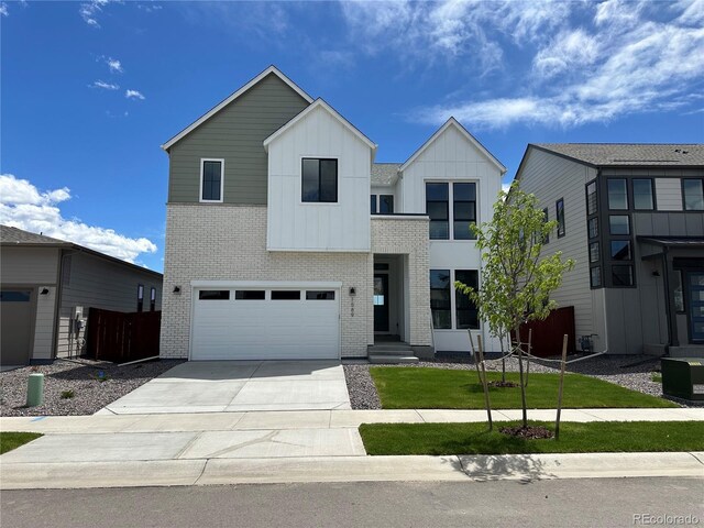 1589 Winter Glow Dr, Windsor, CO 80550 - contemporary house featuring board and batten siding, concrete driveway, a garage, brick siding, and fence