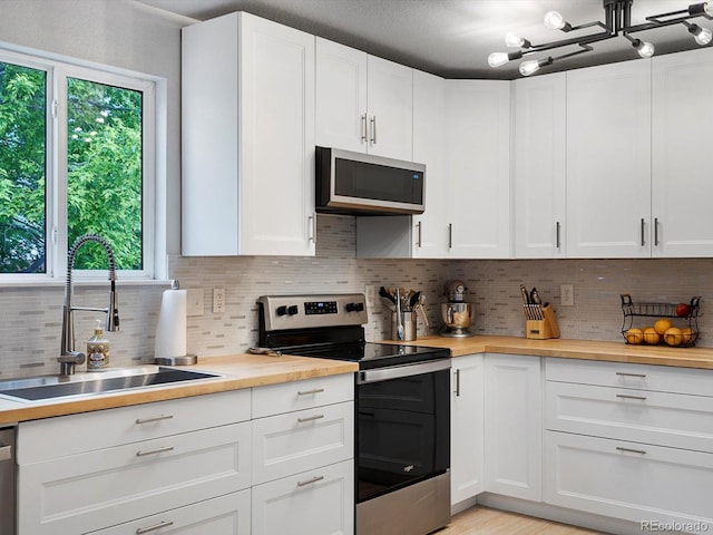 23222 E Orchard Pl, Aurora, CO 80015 - kitchen featuring stainless steel appliances, wood counters, tasteful backsplash, and white cabinets