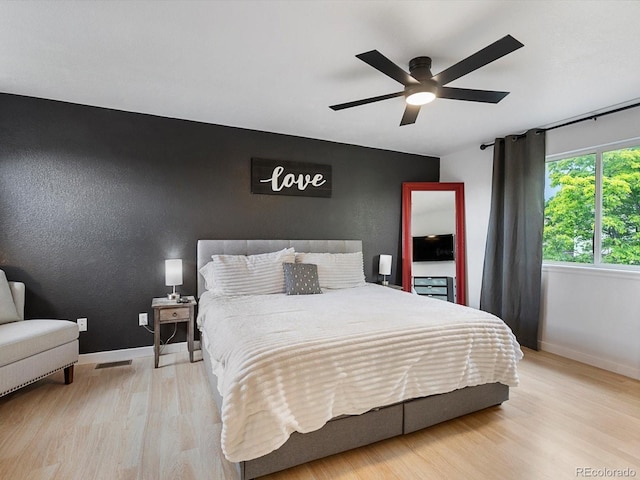 23222 E Orchard Pl, Aurora, CO 80015 - bedroom featuring light wood finished floors, a ceiling fan, and an accent wall