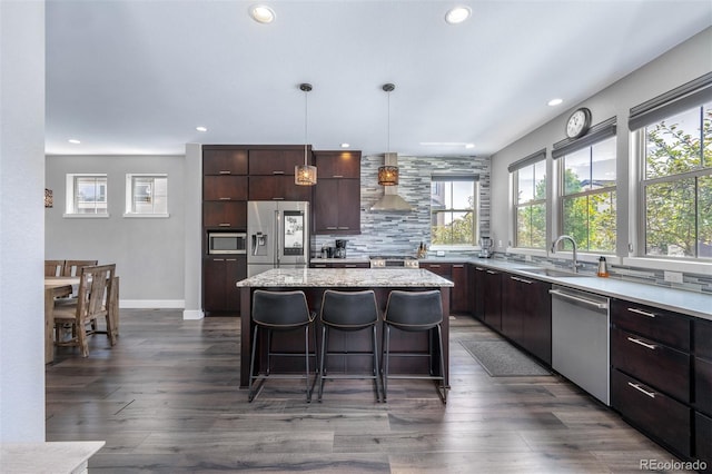 2592 S Norse Ct, Lakewood, CO 80228 - kitchen featuring a breakfast bar, recessed lighting, wall chimney exhaust hood, stainless steel appliances, and a sink