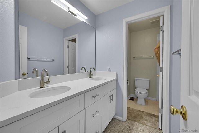 bathroom featuring tile patterned flooring, toilet, and vanity