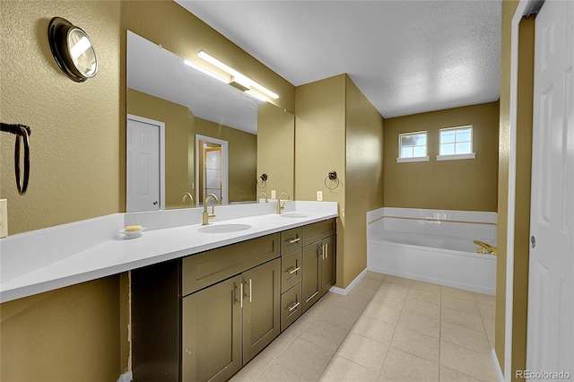 bathroom with a bath, tile patterned flooring, a textured ceiling, and vanity