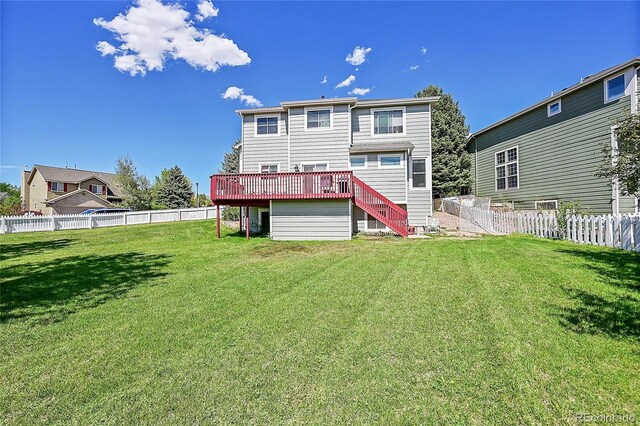 rear view of house featuring a yard and a wooden deck