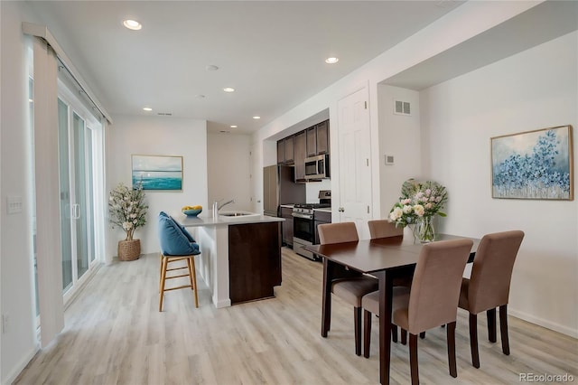 dining space with light wood-type flooring, visible vents, and recessed lighting