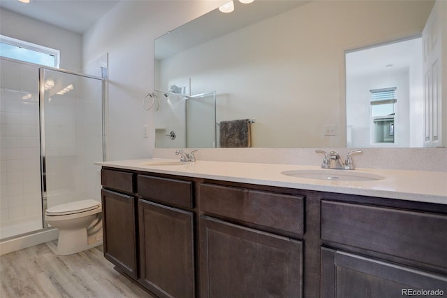 full bath with double vanity, a shower stall, and a sink