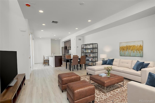 living room featuring recessed lighting, visible vents, and light wood finished floors