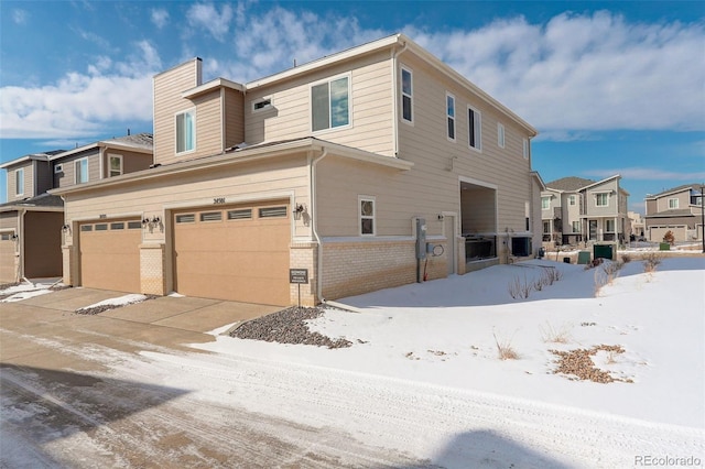 exterior space with brick siding, fence, a garage, a residential view, and driveway