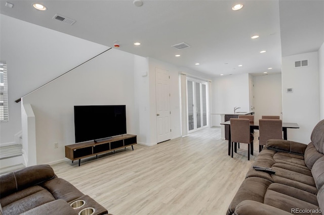 living area featuring light wood-style floors, recessed lighting, and visible vents