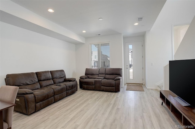 living area with baseboards, light wood-type flooring, visible vents, and recessed lighting