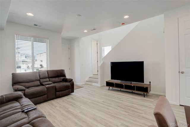 living room with light wood-type flooring, visible vents, and plenty of natural light