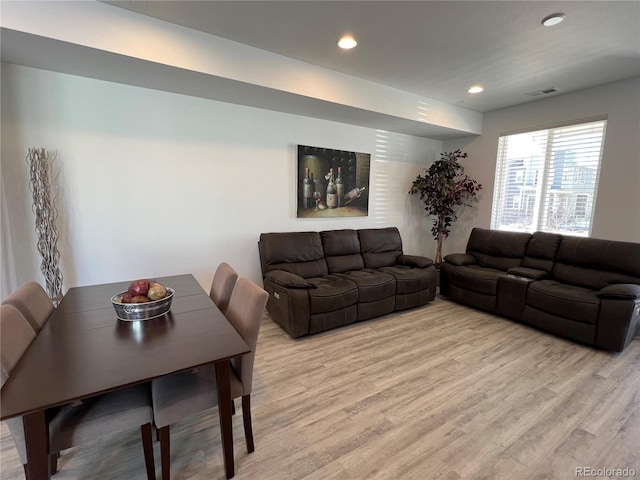 living room with light wood-style floors, visible vents, and recessed lighting