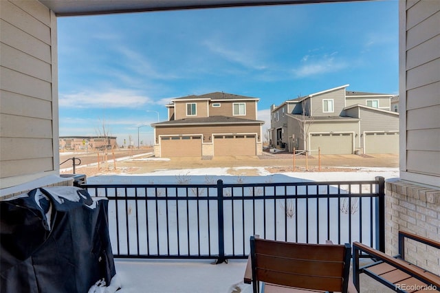 snow covered back of property with a grill and a residential view