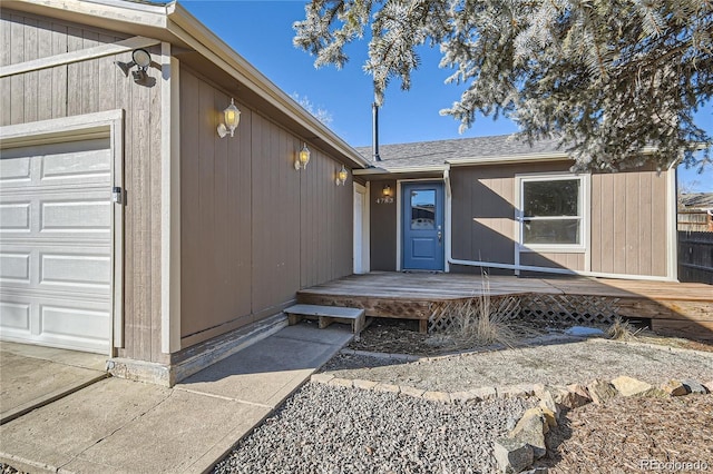 property entrance with an attached garage and a deck