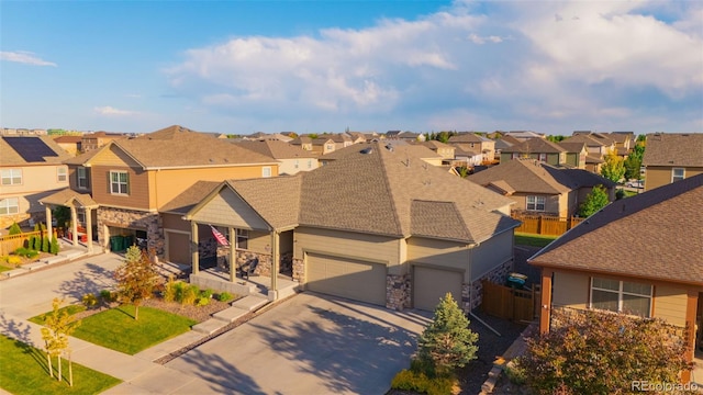 19468 E 65th Pl, Aurora, CO 80019 - view of front of house with a residential view, stone siding, concrete driveway, and roof with shingles