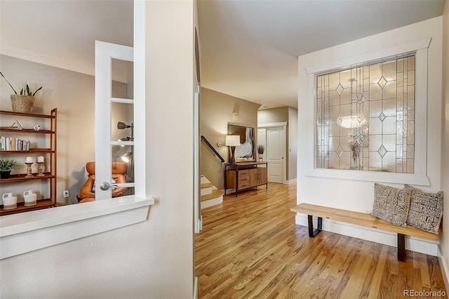 interior space with stairs, wood finished floors, and baseboards