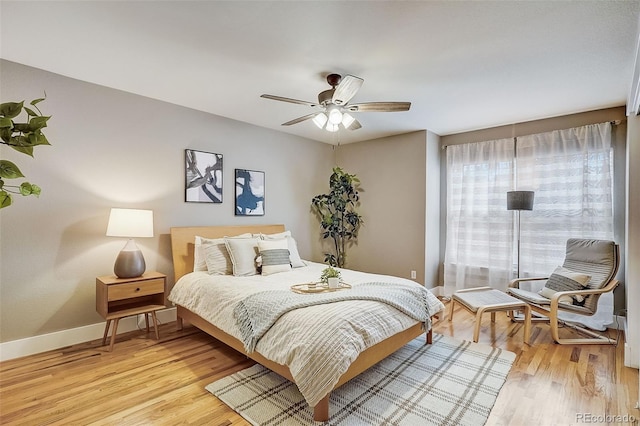 bedroom featuring light wood-style floors, baseboards, and a ceiling fan