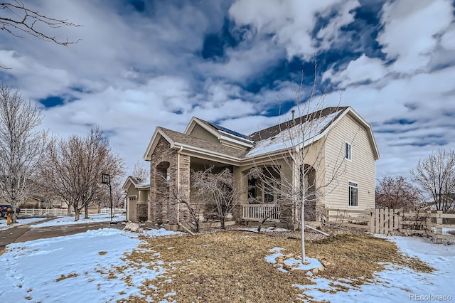 14096 Roaring Fork Cir, Broomfield, CO 80023 - view of snowy exterior with a porch, roof with shingles, and stone siding